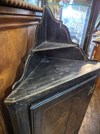 Decorative black Chinese corner cabinet with floral and bird design. This image shows the top of the cabinet.