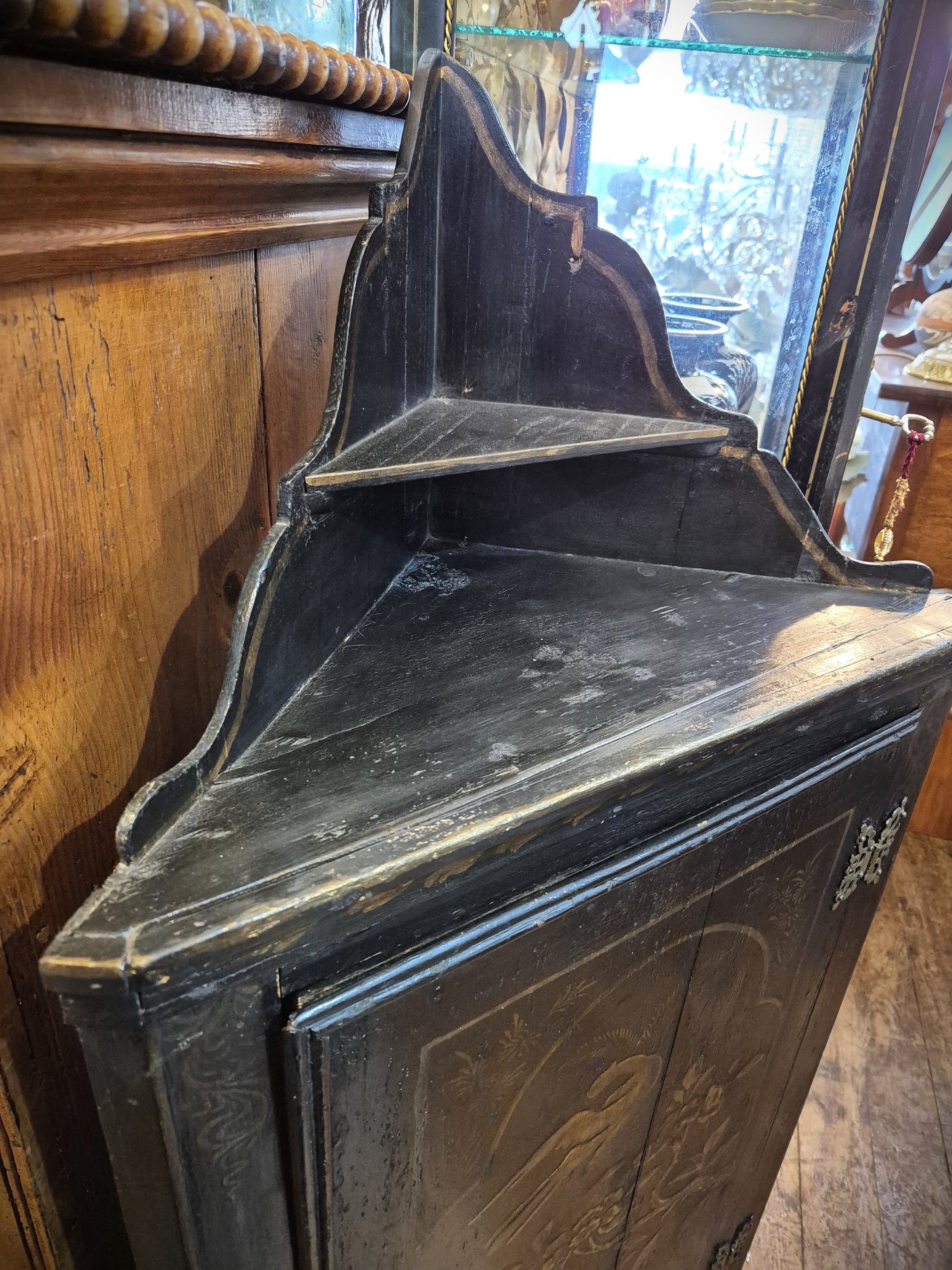 Decorative black Chinese corner cabinet with floral and bird design. This image shows the top of the cabinet.