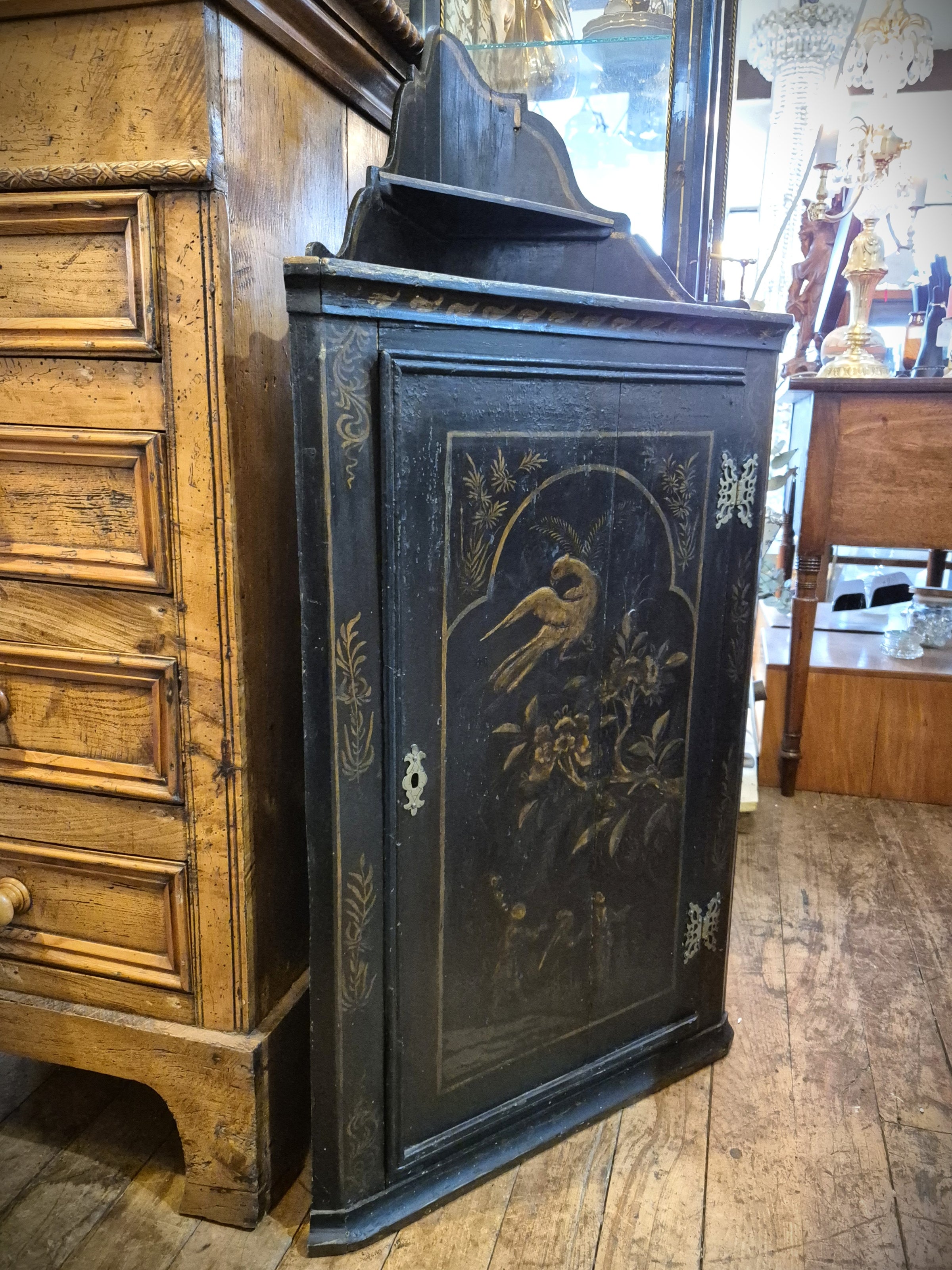 Antique Chinese black Corner Cabinet featuring painted birds and floral designs in gold.
