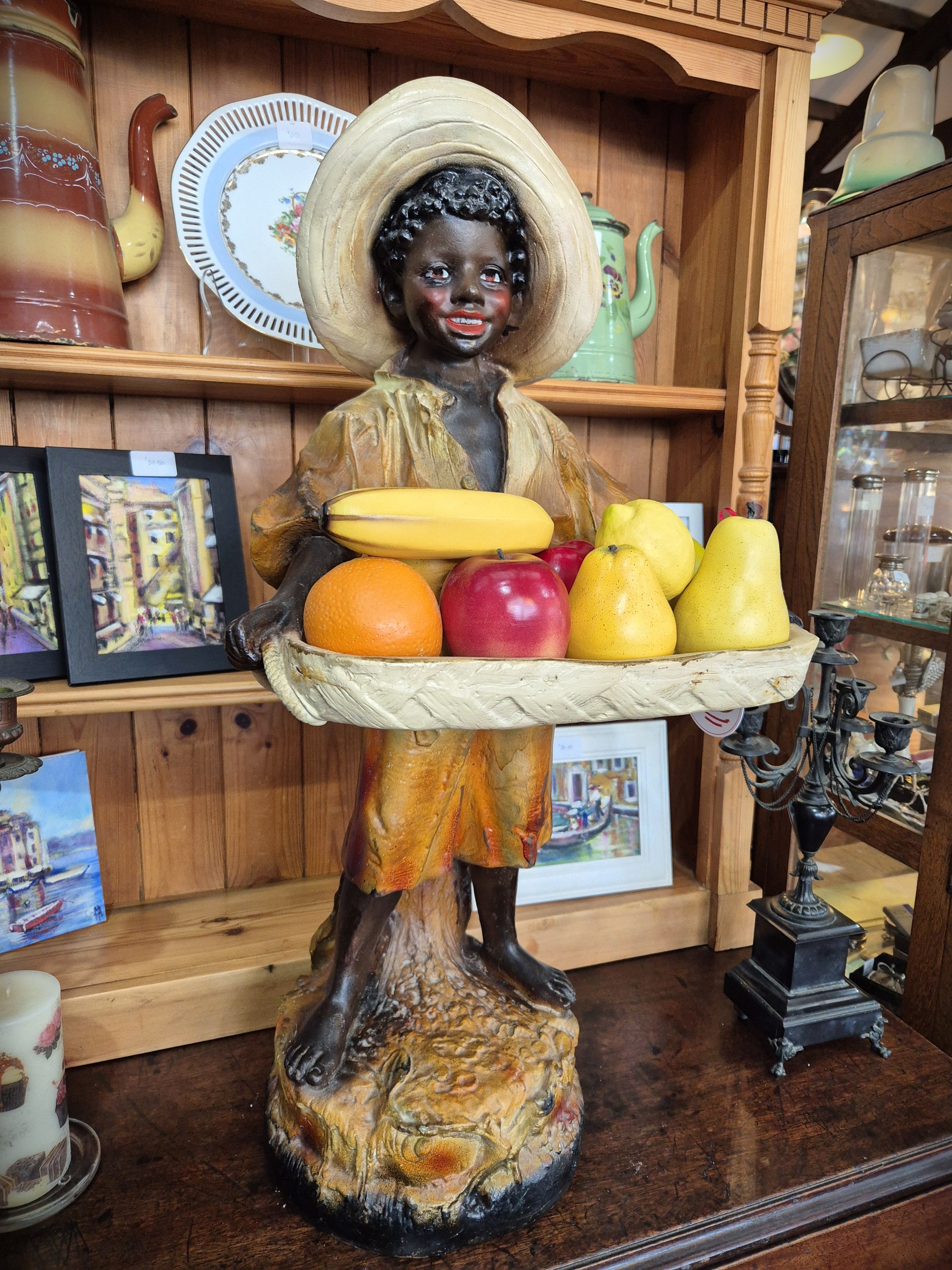 African boy statue carrying fruit