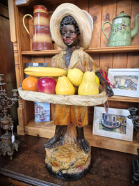 African boy statue carrying fruit