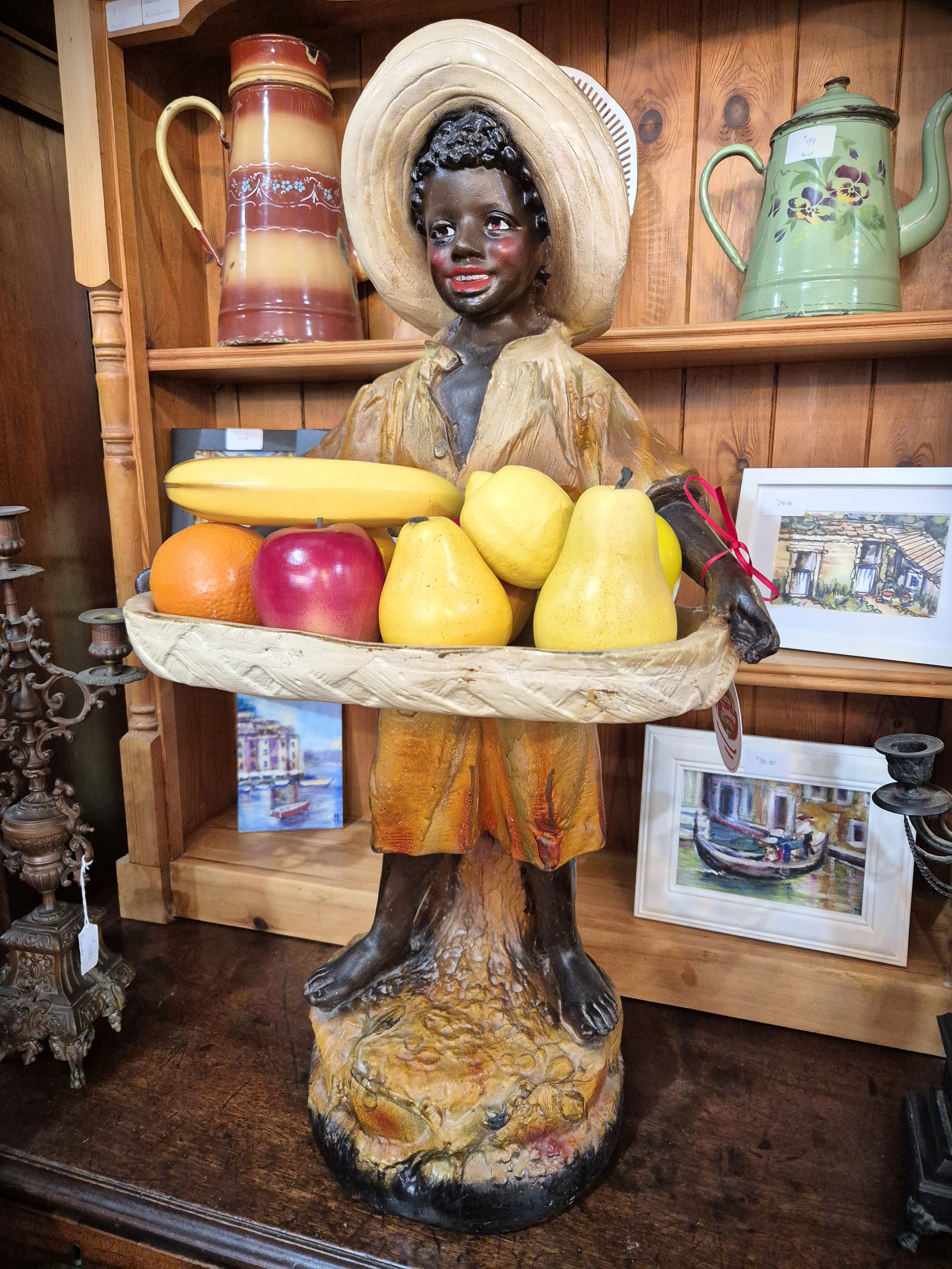 African boy statue carrying fruit