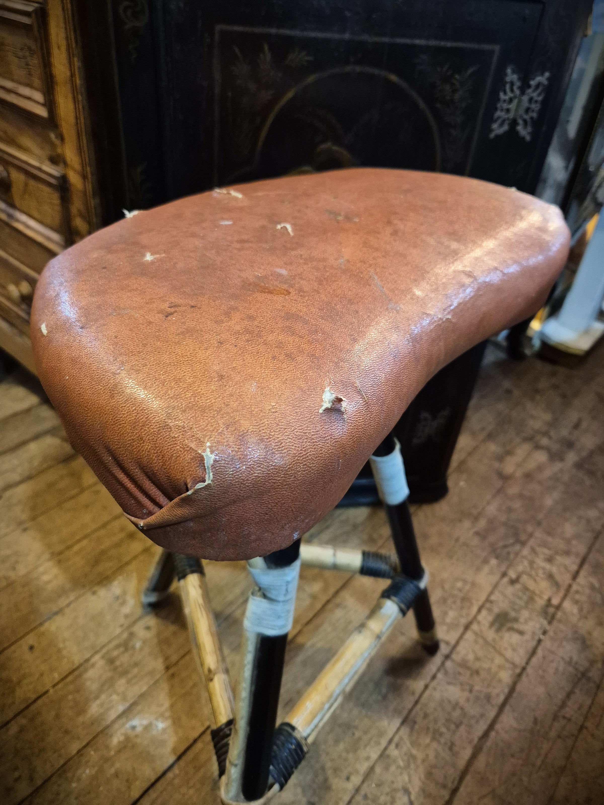 Mid century Kidney shaped seat stool with cane legs with imitation leather seat.