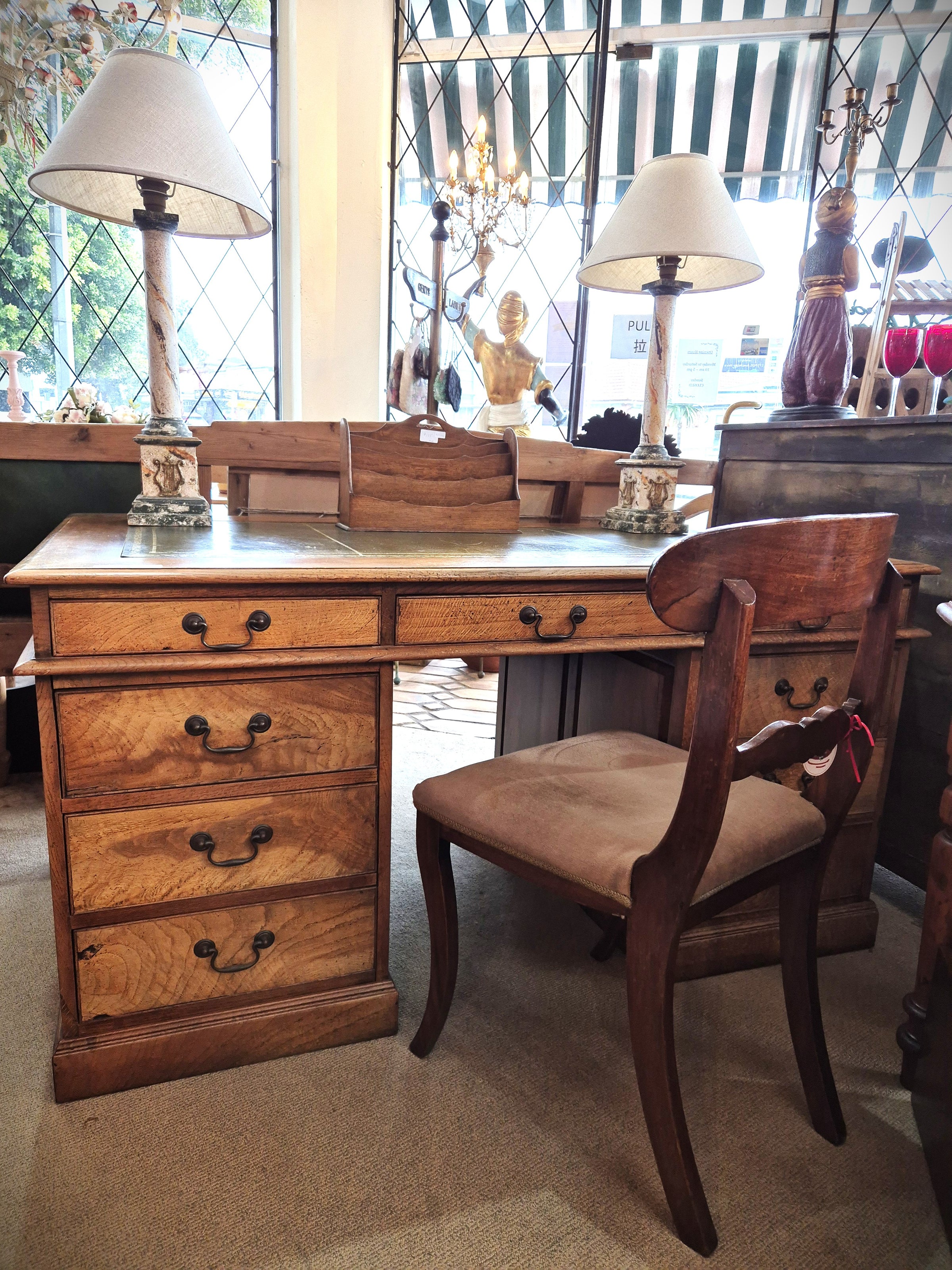 Vintage Oak Partners Desk displayed with two lamps and a chair.
