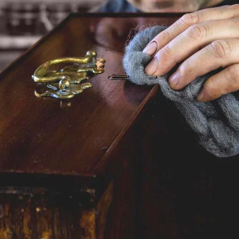 Steel wool.  Photo of someone using Steel Wool to polish furniture with wax.