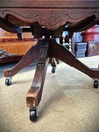 American antique oak swivel office chair close up of the base and casters.