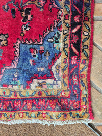Close-up of a colorful Persian rug corner on a textured surface