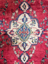 Close-up of a red Persian rug with intricate designs