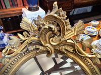 Decorative gold mirror with intricate designs close up.